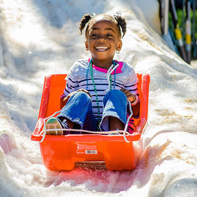 Winter Events child sledding on the snow.